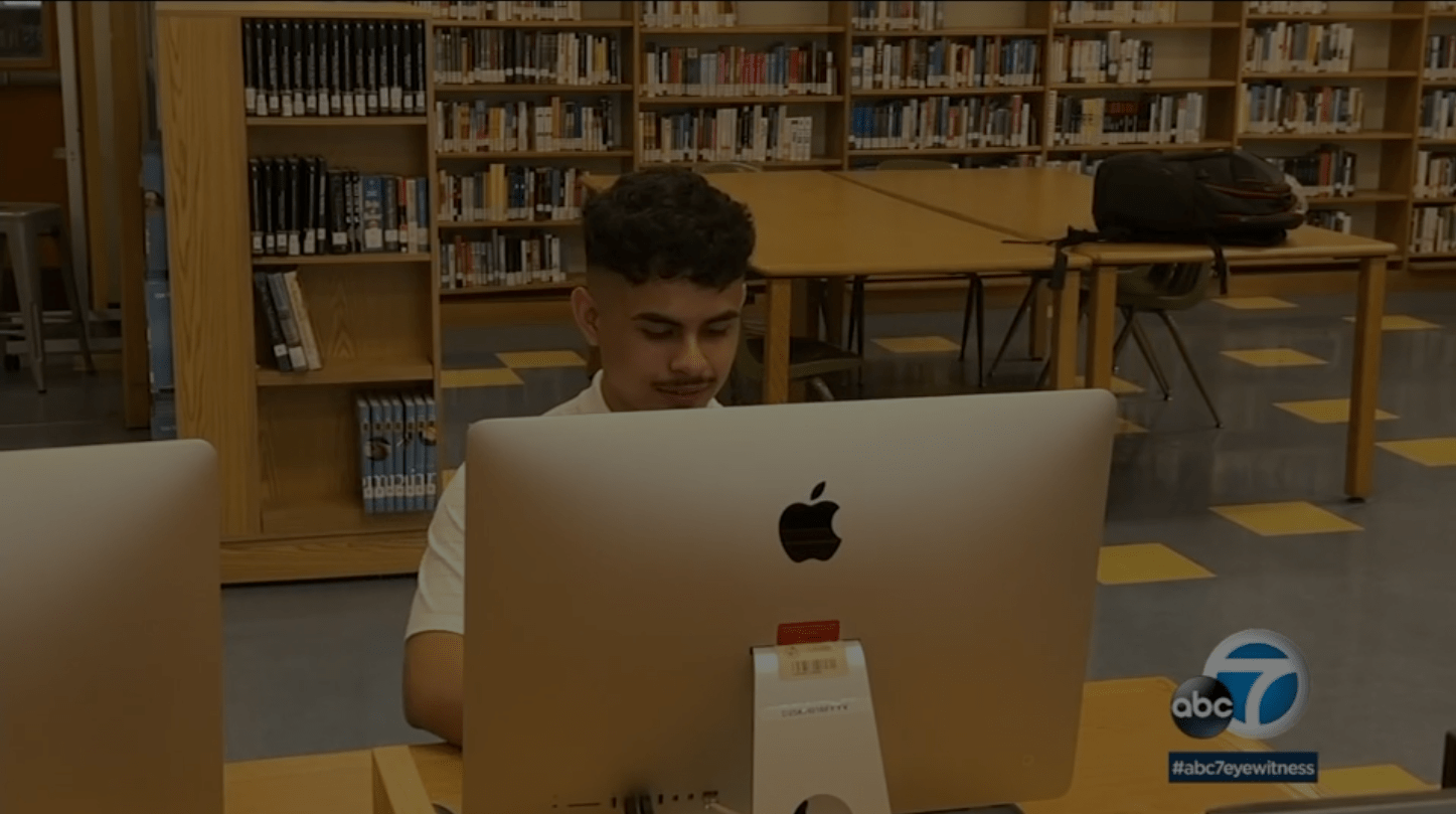 Student studying on an Apple Desktop in the library