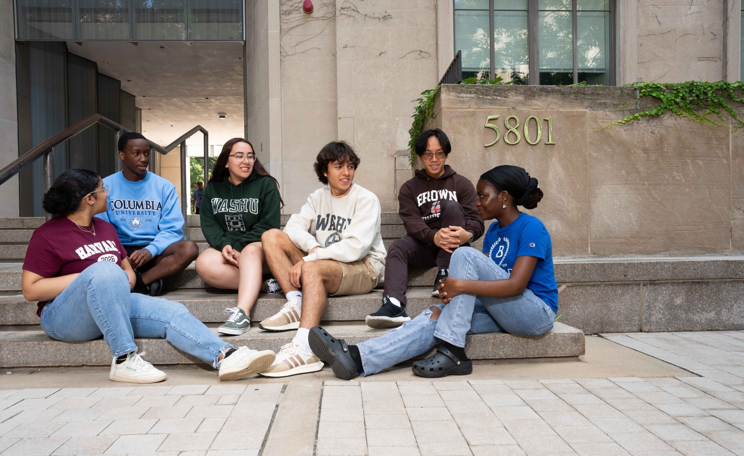 Thrive College students sitting on the step of a college campus building for annual impact report page